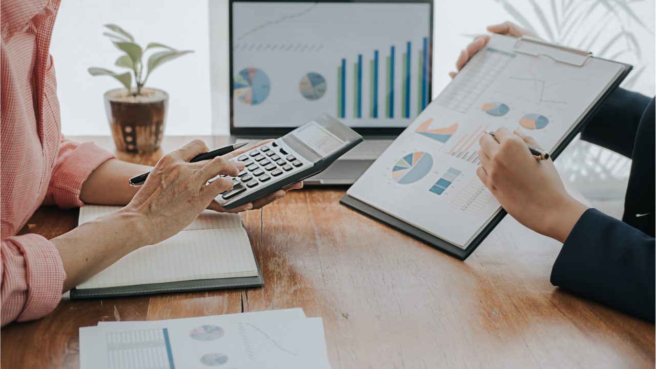 An adviser and a client going through performance charts together at a table
